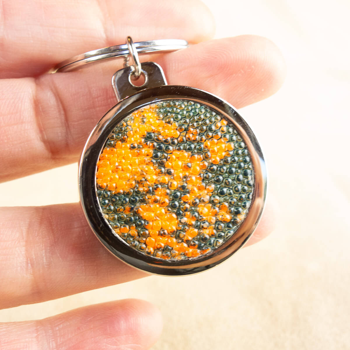 zoom sur le porte-clés décapsuleur en cuir de galuchat orange et vert